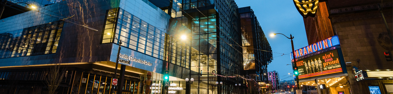 The Pine Plaza entry to Summit lit up at dusk.